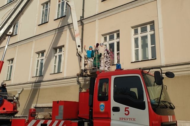 Пожарные Иркутска с подъёмника поздравили детей в больницах с Новым годом